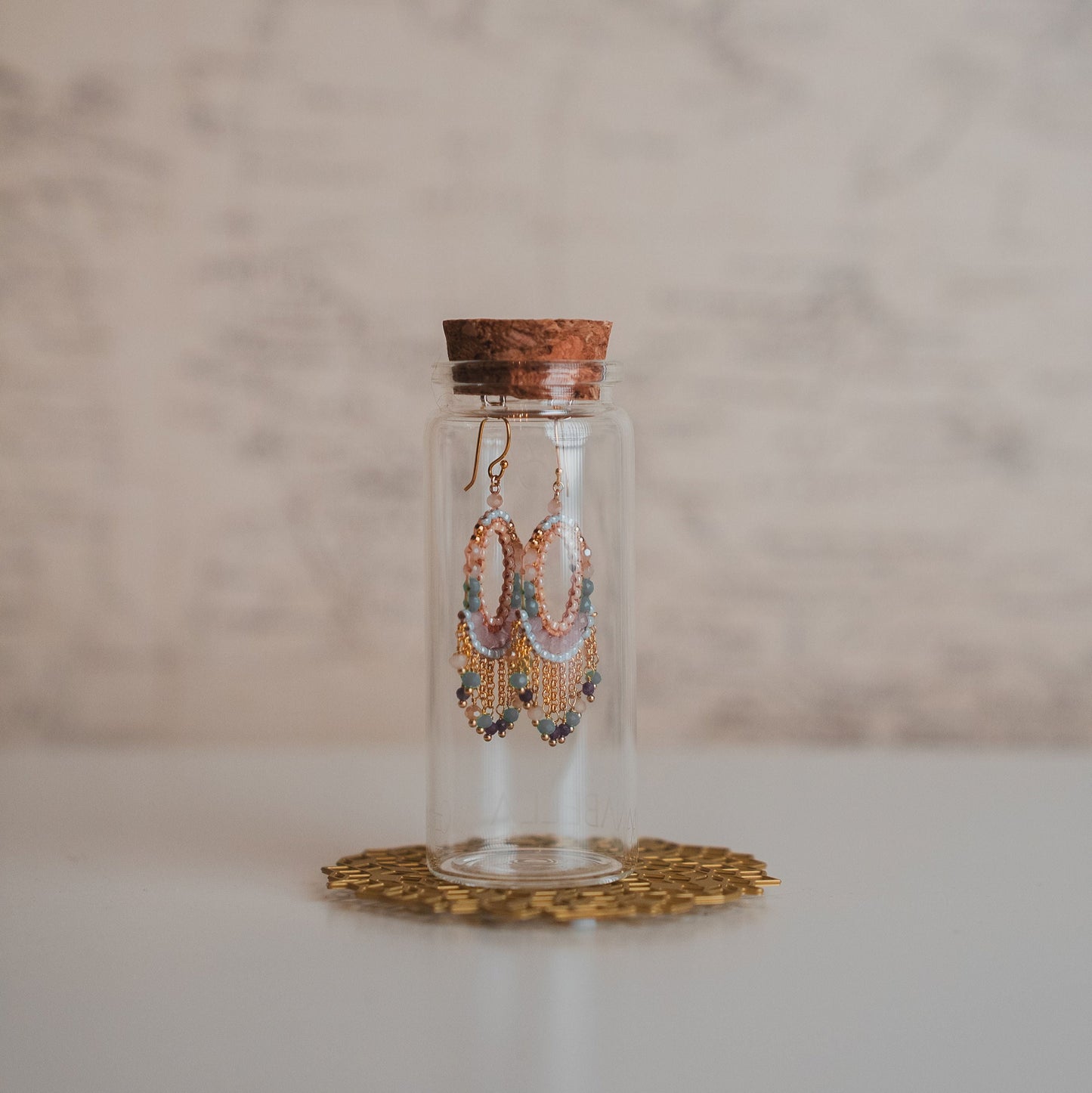 Decorative glass bottle with cork lid on a marble surface