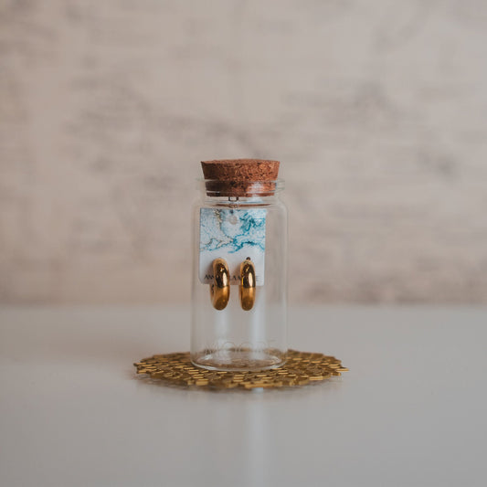 Small glass jar with cork lid on a decorative coaster against a marble background